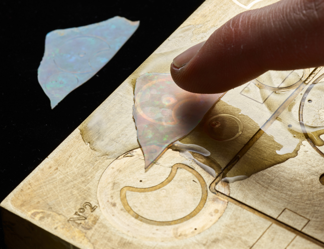 Fixing_an_opal_slice_on_a_heated_base_plate_using_tree_resin_to_make_the_dial_of_the_Romain_Gauthier_Insight_Micro-Rotor_Lady_Opal